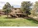 Back view of home showcasing large wooden deck, stairs to backyard, and lush green lawn at 8687 N Pinery Pkwy, Parker, CO 80134
