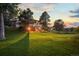Tranquil backyard with a large green lawn and a deck, bathed in the warm glow of the sunset at 8687 N Pinery Pkwy, Parker, CO 80134