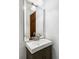Clean, compact half-bathroom with a modern vanity and a large, stylish mirror at 8687 N Pinery Pkwy, Parker, CO 80134