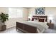 Comfortable bedroom with a wooden-framed bed, neutral tones, and natural light from the window at 8687 N Pinery Pkwy, Parker, CO 80134