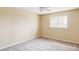 This is an empty staged bedroom with modern gray carpet, a large window, and a ceiling fan at 8687 N Pinery Pkwy, Parker, CO 80134