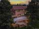 Two-story home featuring a spacious back deck, patio, neutral exterior and brick-red roof at 8687 N Pinery Pkwy, Parker, CO 80134