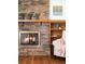 Cozy living room featuring a classic brick fireplace with a wooden mantel and bookcase at 8687 N Pinery Pkwy, Parker, CO 80134