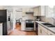 Galley kitchen with stainless steel appliances, light countertops, and a terracotta tile floor at 8687 N Pinery Pkwy, Parker, CO 80134