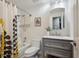 Full bathroom with a shower-tub combo, gray vanity, and floral shower curtain at 10909 W 65Th Way, Arvada, CO 80004