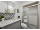 Updated bathroom featuring a vanity with marble top and tiled shower with glass door at 10909 W 65Th Way, Arvada, CO 80004