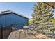 Outdoor deck seating area with metal chairs and table overlooking the green space and mature trees at 10909 W 65Th Way, Arvada, CO 80004