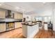 Open kitchen featuring stainless appliances, stone counters, a large island, and hardwood floors at 1560 Blake St # 810, Denver, CO 80202
