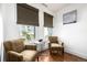 Cozy sitting area featuring two chairs, a small table, and natural light from two windows with stylish shades at 1560 Blake St # 810, Denver, CO 80202