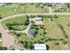 Aerial view of the property with multiple outbuildings and mature trees surrounding the home at 2882 Gentry Ct, Watkins, CO 80137