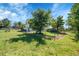 Green fenced-in backyard surrounded by trees, with a home visible in the background at 2882 Gentry Ct, Watkins, CO 80137