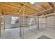 Unfinished basement with exposed ceiling joists, concrete walls, and metal shelving for storage at 2882 Gentry Ct, Watkins, CO 80137