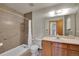 A clean bathroom with a neutral color shower, light wood vanity, and updated fixtures at 2882 Gentry Ct, Watkins, CO 80137