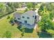 Back of a two-story yellow home with a large yard, a cozy patio, and complemented by lush green trees at 2882 Gentry Ct, Watkins, CO 80137