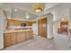 Kitchen featuring wooden cabinets, a pantry, an island and access to the home's entryway at 2882 Gentry Ct, Watkins, CO 80137