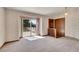 Bright living room with sliding glass doors leading to a deck and neutral colored carpet flooring at 2882 Gentry Ct, Watkins, CO 80137