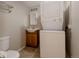 Bathroom featuring a vanity, stacked washer and dryer, and a toilet at 916 Florence St, Aurora, CO 80010