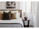 Close up of bed with headboard, bedside table, lamp, and natural light at 916 Florence St, Aurora, CO 80010