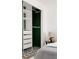 Bedroom closet with modular shelving and green accent wall at 916 Florence St, Aurora, CO 80010