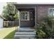 Cozy front porch with stone accents, a small lawn, and well-kept landscaping at 916 Florence St, Aurora, CO 80010