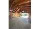 Spacious garage with exposed beams, a concrete floor, and an open garage door at 916 Florence St, Aurora, CO 80010
