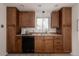 A well-lit kitchen with matching cabinetry and black dishwasher beneath a window at 916 Florence St, Aurora, CO 80010