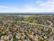 Wide aerial view of the neighborhood with a lake, school, and surrounding houses at 3881 S Bahama St, Aurora, CO 80013