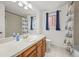 Bathroom with wood cabinets, white sink, toilet, shower and tiled floor at 3881 S Bahama St, Aurora, CO 80013