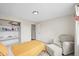Bright bedroom featuring a large bedside chair, built-in shelves, and carpeted floor at 3881 S Bahama St, Aurora, CO 80013