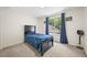 This bedroom has a black bed, a large window, and soft carpet at 3881 S Bahama St, Aurora, CO 80013