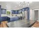 Modern kitchen with a central island, stainless steel appliances, and custom blue cabinetry at 3881 S Bahama St, Aurora, CO 80013