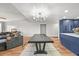 Open-concept living room with wood floors, modern light fixture, and view of kitchen at 3881 S Bahama St, Aurora, CO 80013