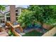 This backyard features a deck, brick patio, artificial grass, trees, landscaping, and blue lawn chairs at 6375 S Jackson St, Centennial, CO 80121