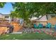 This backyard features a deck, trees, landscaping, artificial grass, and blue lawn chairs at 6375 S Jackson St, Centennial, CO 80121