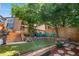 Backyard includes a wooden deck, mature trees, landscaping, artificial grass, and blue lawn chairs at 6375 S Jackson St, Centennial, CO 80121