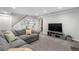 Spacious carpeted basement featuring a large sofa, TV, and built-in shelves at 6375 S Jackson St, Centennial, CO 80121