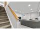 Finished basement with a carpeted living area and staircase with wooden railing at 6375 S Jackson St, Centennial, CO 80121
