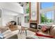 Bright living room with high ceilings, fireplace, large windows, and hardwood floors at 6375 S Jackson St, Centennial, CO 80121