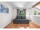 Cozy living room features wood floors, a comfortable sofa bed, and large windows at 6375 S Jackson St, Centennial, CO 80121