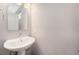 A charming bathroom features a pedestal sink, framed mirror, and modern lighting at 1245 Utica St # 104, Denver, CO 80204