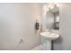 Bright powder room features a pedestal sink with chrome faucet and a rectangular mirror at 1245 Utica St # 104, Denver, CO 80204