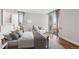 Bright bedroom boasts wood floors, neutral decor, a large window, and sliding glass door to the balcony at 955 Eudora St # 505E, Denver, CO 80220