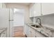 Modern kitchen featuring white cabinets, granite counters, and stainless steel sink at 955 Eudora St # 505E, Denver, CO 80220