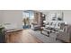 Sunlit living room features stylish furniture, wood floors, a neutral rug, and sliding doors to the balcony at 955 Eudora St # 505E, Denver, CO 80220