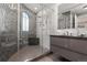 Stylish bathroom showcasing a glass-enclosed shower, decorative wall tiles, and a sleek vanity with a dark countertop at 150 S Madison St # 303, Denver, CO 80209