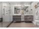 Modern bathroom featuring double vanity, elegant mirrors, and a spacious glass-enclosed shower with unique textured walls at 150 S Madison St # 303, Denver, CO 80209