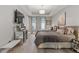 Bright bedroom with two beds, tray ceiling, modern lighting, and a decorative console with wall-mounted television at 150 S Madison St # 303, Denver, CO 80209