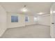 Expansive basement area with neutral carpet, three windows providing natural light and a white door at 11247 Wyandot St, Denver, CO 80234