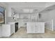 Well-lit kitchen with an island, white appliances, and tiled flooring at 11247 Wyandot St, Denver, CO 80234