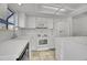 Kitchen featuring tiled flooring, white appliances and cabinetry, and bright lighting at 11247 Wyandot St, Denver, CO 80234